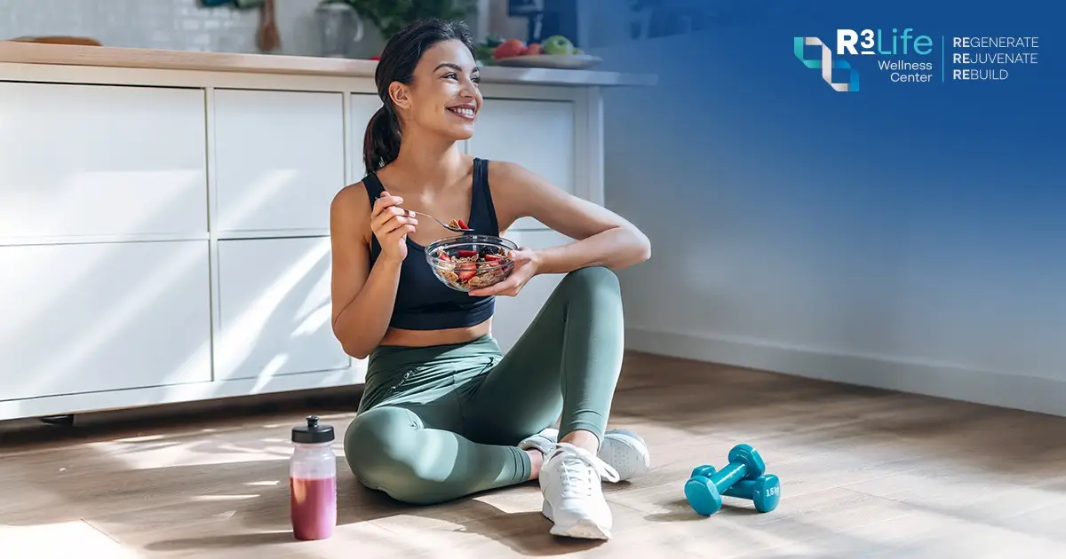 Athletic woman eating a healthy meal beside a smoothie and dumbbells to support muscle recovery
