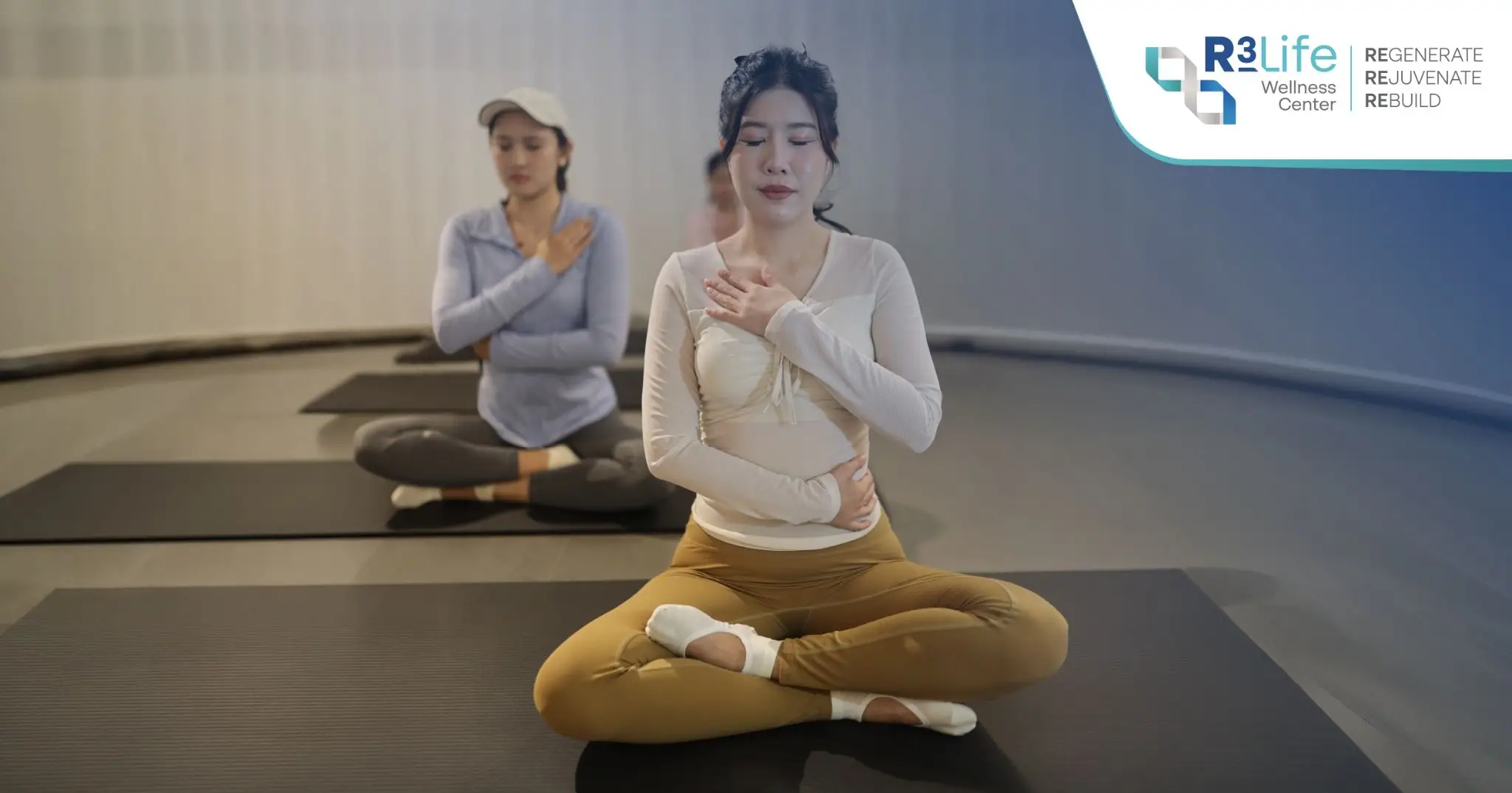 Participants practicing breath awareness with hands on the chest and abdomen during a Mindful Mat Pilates class at ANAPANA SATI